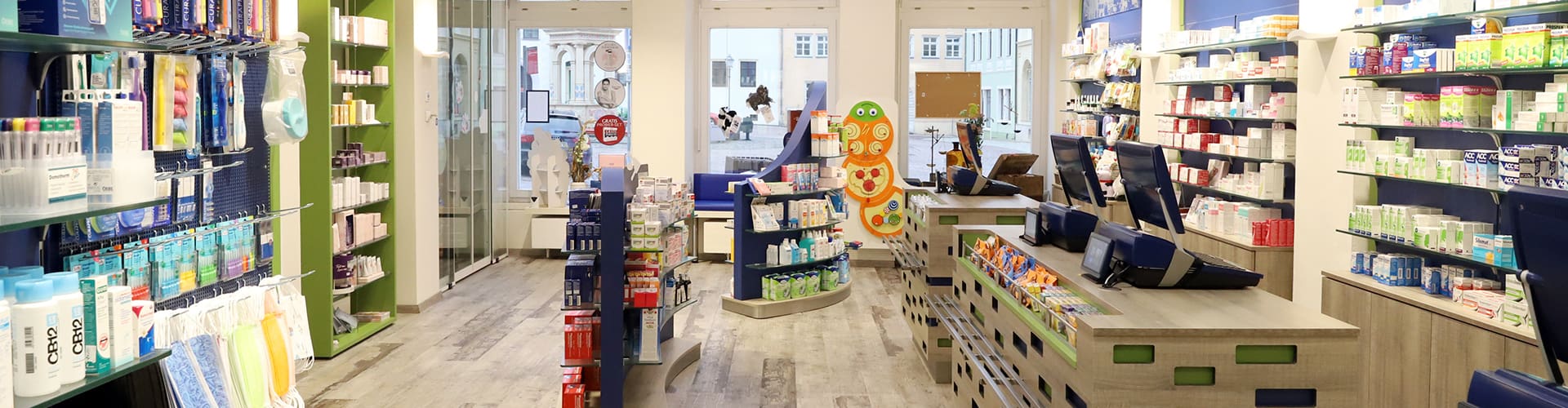 Löwen-Apotheke Oschatz Blick durch gesamten Verkaufsraum mit Kassenbereich rechts & Fensterfront im Hintergrund