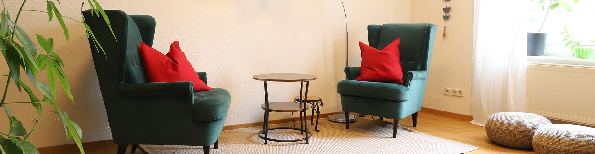 Referenz Praxis für Psychotherapie Peterhänsel Leipzig Sprechzimmer in gemütlicher Atmosphäre mit zwei grünen Sesseln, einem kleinen Tisch und einer weißen Stehlampe auf einem Teppich